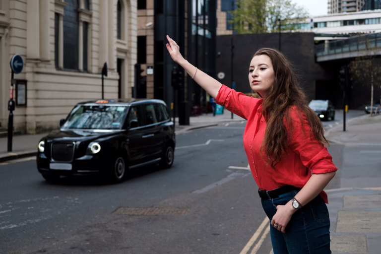 Young woman hailing black cab in London. Get clear, data-driven campaign reporting and insights for your taxi advertising with Illumin8 to track performance and maximise ROI.